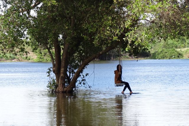 Fille sur une balançoire au milieu de l'eau