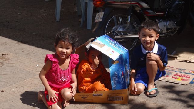 Enfants s'amusant avec une grande boite en carton