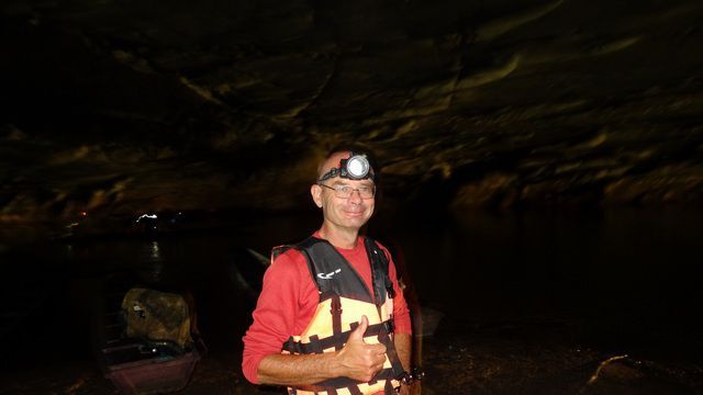 Moi avec une lampe frontale et un gilet de sauvetage pour la visite de la grotte
