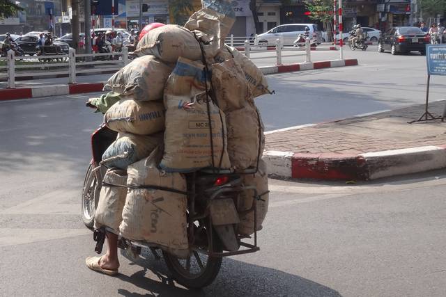 Scooter surchargé avec des sacs de gravats