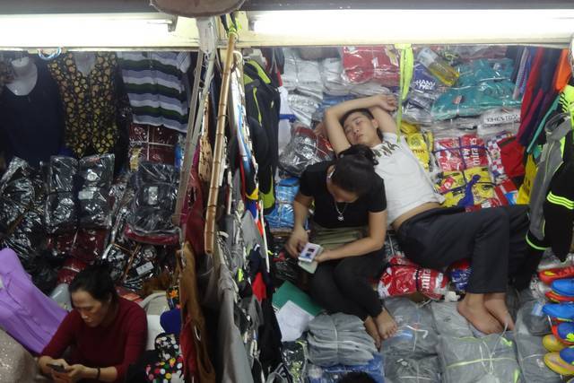 Vendeuse de tissus dans un marché à Hanoï