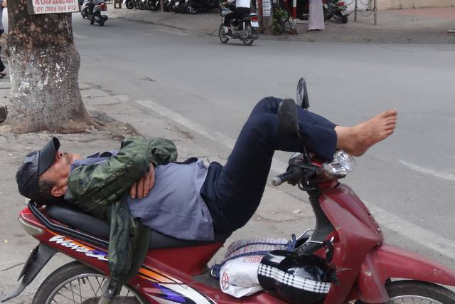 Vietnamien en train de faire la sieste sur son scooter