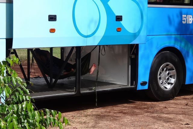 Chauffeur faisant la sieste dans la soute à bagage d'un bus